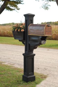 a mailbox with flowers in it sitting on the side of a road