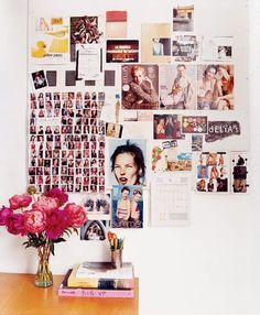 a desk with flowers and pictures on the wall