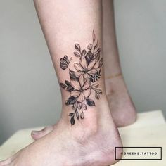 a woman's foot with a flower tattoo on it