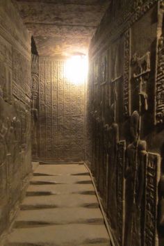 an image of a hallway in the egyptian temple with light at the end and carvings on the walls