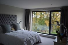 a bedroom with a large window and white bed in front of the sliding glass door