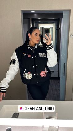 a woman taking a selfie with her cell phone in front of an elevator door