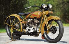 a yellow motorcycle parked on top of a cement road