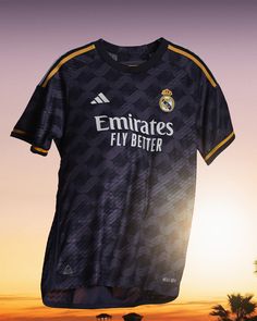 a soccer jersey is hanging on a clothes line in front of palm trees at sunset