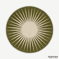 a green and white circular rug with sunbursts on the center, in front of a white background