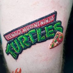 a close up of a person's leg with a tattoo that says teenage mutant ninjas