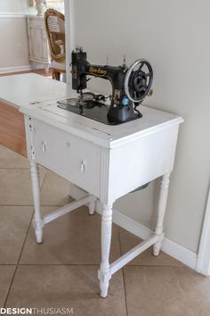 a sewing machine sitting on top of a white table next to a wall mounted clock