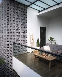 a living room filled with furniture next to a wooden table and wall mounted planter