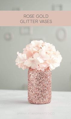 a pink vase filled with flowers on top of a white table next to the words rose gold glitter vases