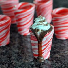 candy canes with whipped cream and chocolate drizzled on them are lined up