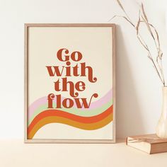 a poster with the words go with the flow on it next to a book and vase