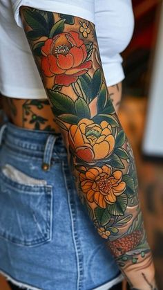 a woman's arm with flowers on it, and an orange flower in the middle