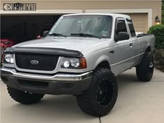 a silver truck parked in front of a garage