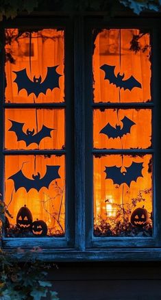 the window is decorated with bats and pumpkins