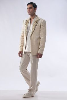 Golden beige tuxedo jacket with honeycomb pattern, highlighted with hand embroidery on lapel. Paired with an inner golden beige kurta and trouser. - Aza Fashions Fitted Blazer For Reception, Embellished Long Sleeve Bandhgala For Semi-formal Events, Embellished Long Sleeve Semi-formal Bandhgala, Formal Long Sleeve Embellished Nehru Jacket, Elegant Embellished Fitted Nehru Jacket, Elegant Long Sleeve Blazer For Reception, Festive Tailored Embellished Blazer, Festive Embellished Tailored Blazer, Embellished Fitted Outerwear For Wedding