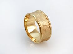 a gold wedding ring on a white background