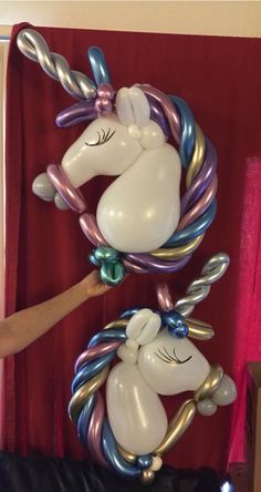 two balloons shaped like unicorns hanging on a wall