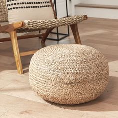 a chair and footstool sitting on the floor in front of a woven ottoman