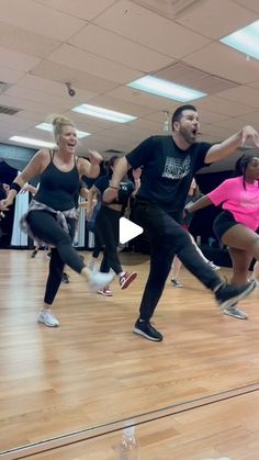 a group of people are dancing on a wooden floor