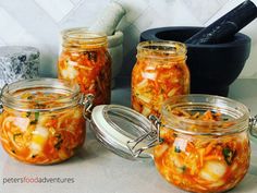 four jars filled with food sitting on top of a counter