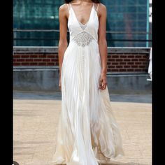 a model walks down the runway in a white dress