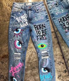 two pairs of jeans with eyeballs painted on them, one has the words born to be free