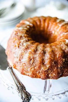 a bundt cake sitting on top of a white plate next to a knife and fork