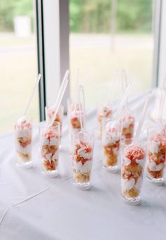 small cups filled with food sitting on top of a white table covered in frosting