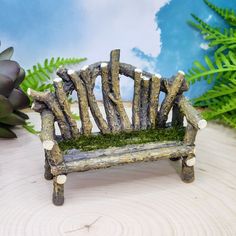 a miniature bench made out of logs and moss