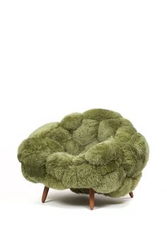 a green chair sitting on top of a wooden base