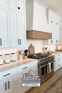 a kitchen with white cabinets and stainless steel stove top oven, range hood and counter tops