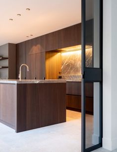 an open kitchen and living room area in a modern home with dark wood cabinetry