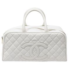 A sophisticated white caviar leather top handle bag with gold hardware and zipper closure. The grosgrain interior includes one pocket for organization. SPECIFICS Length: 14.6 Width: 4.7 Height: 7.9 Strap drop: 4 Authenticity code: 8163726 (2003-2004) Comes with: SDC Dust bag Chanel White, Louis Vuitton Keepall, Chanel Vintage, White Quilt, Vintage Bag, John Galliano, Handle Bag, Leather Top, Fashion Handbags