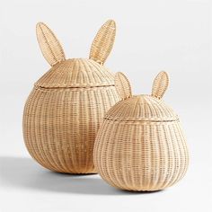 two wicker baskets with bunny ears on the top one is empty and the other has an open lid