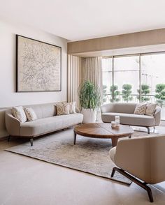 a living room with couches, chairs and a coffee table in front of a large window