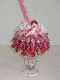 a glass vase with candy in it and a pink candle sticking out of the top