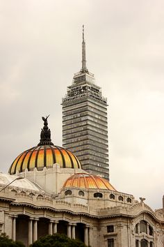 the top of a building with a large dome in front of it and a clock tower behind it