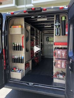 the back end of a van with its doors open and tools in it's cargo compartment