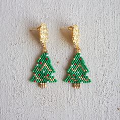 Our  Beaded Christmas Tree Earrings with Miyuki Delicas  are the perfect Christmas jewelry for a festive look!  Each earring is carefully handcrafted with tiny, colorful Miyuki Delica beads to create a charming Christmas tree design. These earrings are like wearing a piece of holiday magic on your ears!  Our Christmas tree earrings are lightweight and easy to wear. They dangle gently, so you can show off your holiday spirit with every step you take. 🎉💃 Whether you're getting ready for a holiday party, school play, or just want to add a touch of Christmas cheer to your outfit, these earrings are the perfect choice. You'll sparkle and shine like a star atop a beautifully decorated tree.  Give the gift of Christmas joy with these delightful earrings. They come in a cute little box, ready to Christmas Gift Beaded Drop Earrings, Holiday Handmade Beaded Earrings Gift, Handmade Beaded Earrings For Holiday Gifts, Handmade Beaded Earrings For Christmas, Handmade Beaded Earrings For Christmas Holiday, Handmade Beaded Earrings For Christmas Gift, Festive Christmas Beaded Earrings, Handmade Jewelry For New Year Holiday, Handmade Festive Earrings For Christmas