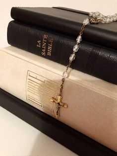 three books stacked on top of each other with a chain attached to the book ends