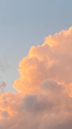 the plane is flying high in the sky with some clouds behind it and an airplane on top