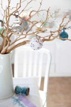 a white vase filled with ornaments on top of a table