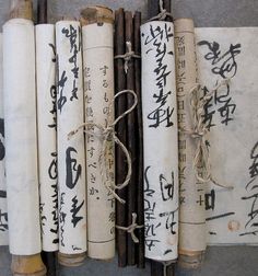 four wooden sticks with writing on them are lined up next to each other and tied together