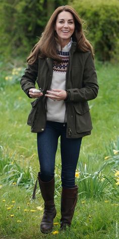 a woman in boots is walking through the grass