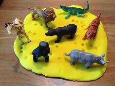 there are many toy animals on the yellow plate