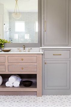 a bathroom vanity with two sinks and cabinets in grey, white and gold colors on instagram