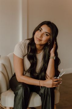 a woman sitting on top of a white chair