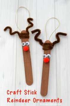 two reindeer stick ornaments made out of brown paper and yarn with red noses on them