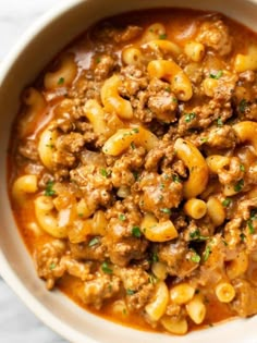 a white bowl filled with pasta and meat