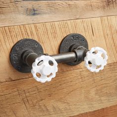 two white knobs are attached to a wooden door